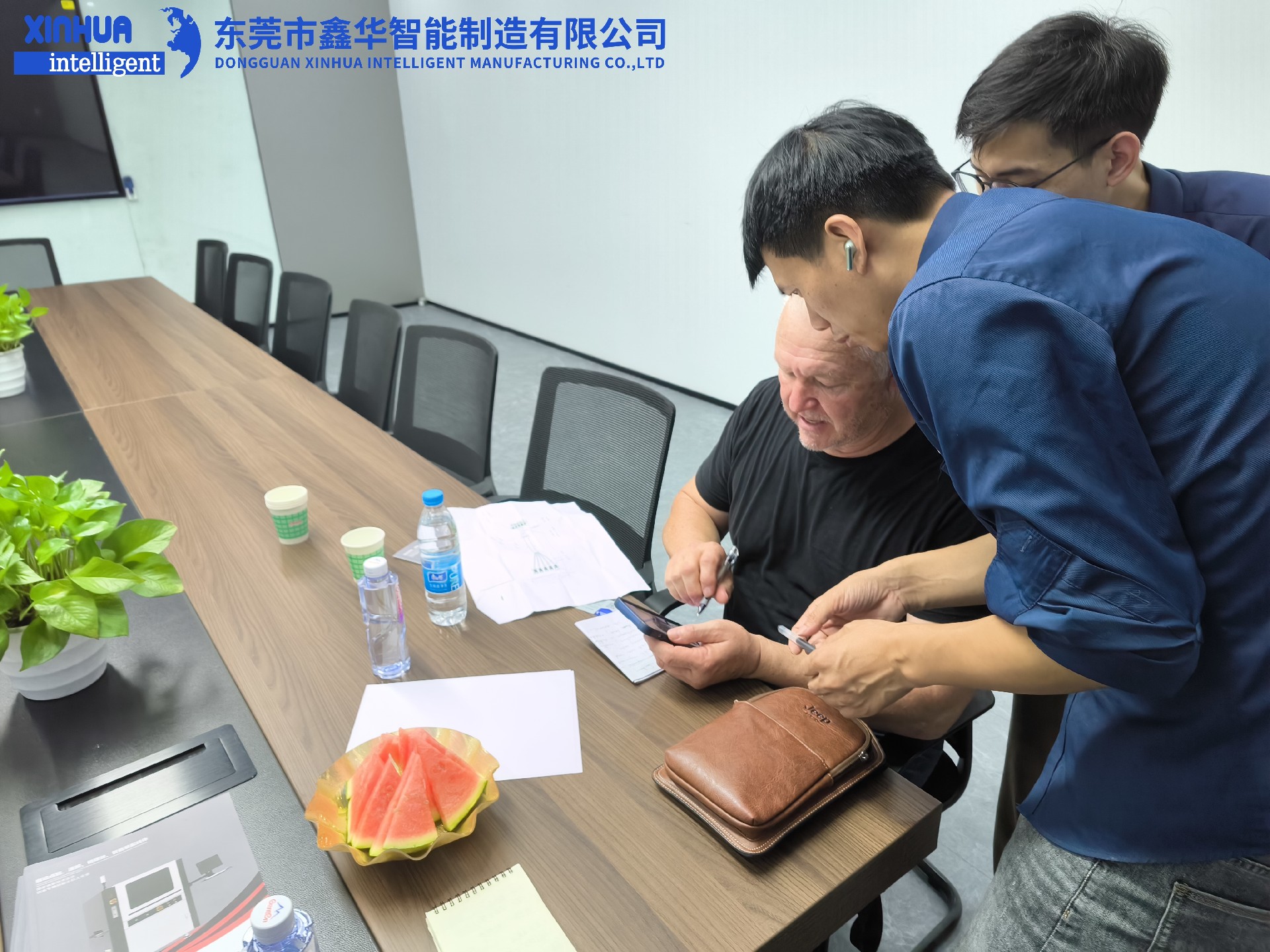 業(yè)務部2位男同事在給美國客戶耐心介紹自動鎖螺絲機性能
